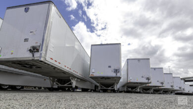 A row of white trailers sit in a lot