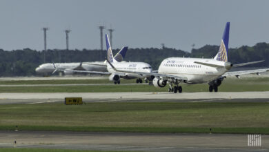 Blue-tailed United Airlines planes on the taxiway.