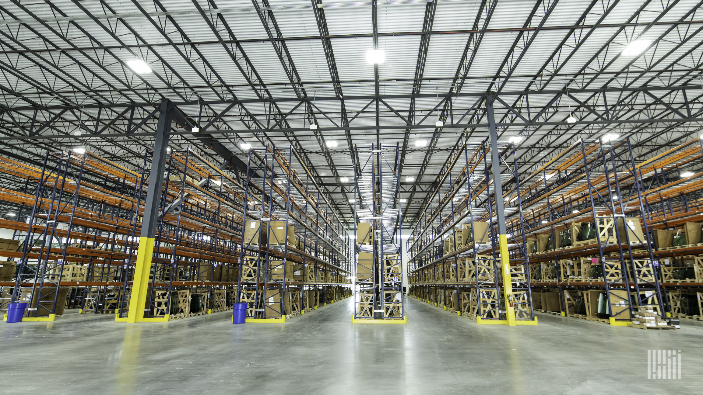 Inside a warehouse, aisles and bright lighting are visible.