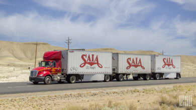 A red Saia tractor pulling three Saia trailers