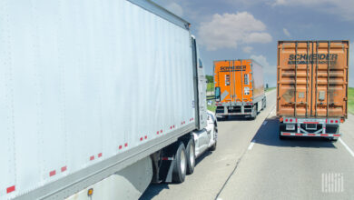 A Schneider tractor-trailer next to a Schneider intermodal container being pulled on a highway