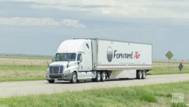 A white tractor pulling a Forward Air trailer on a highway