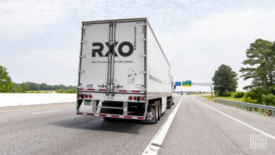 A white RXO trailer being pulled on a highway