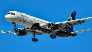 A black-tailed Northern Pacific jet comes in for a landing against a blue sky.