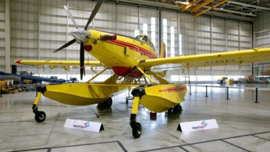 A yellow, single-engine seaplane sits in a hangar.