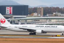 A Japan Airlines jet with red tail logo taxis to the runway.