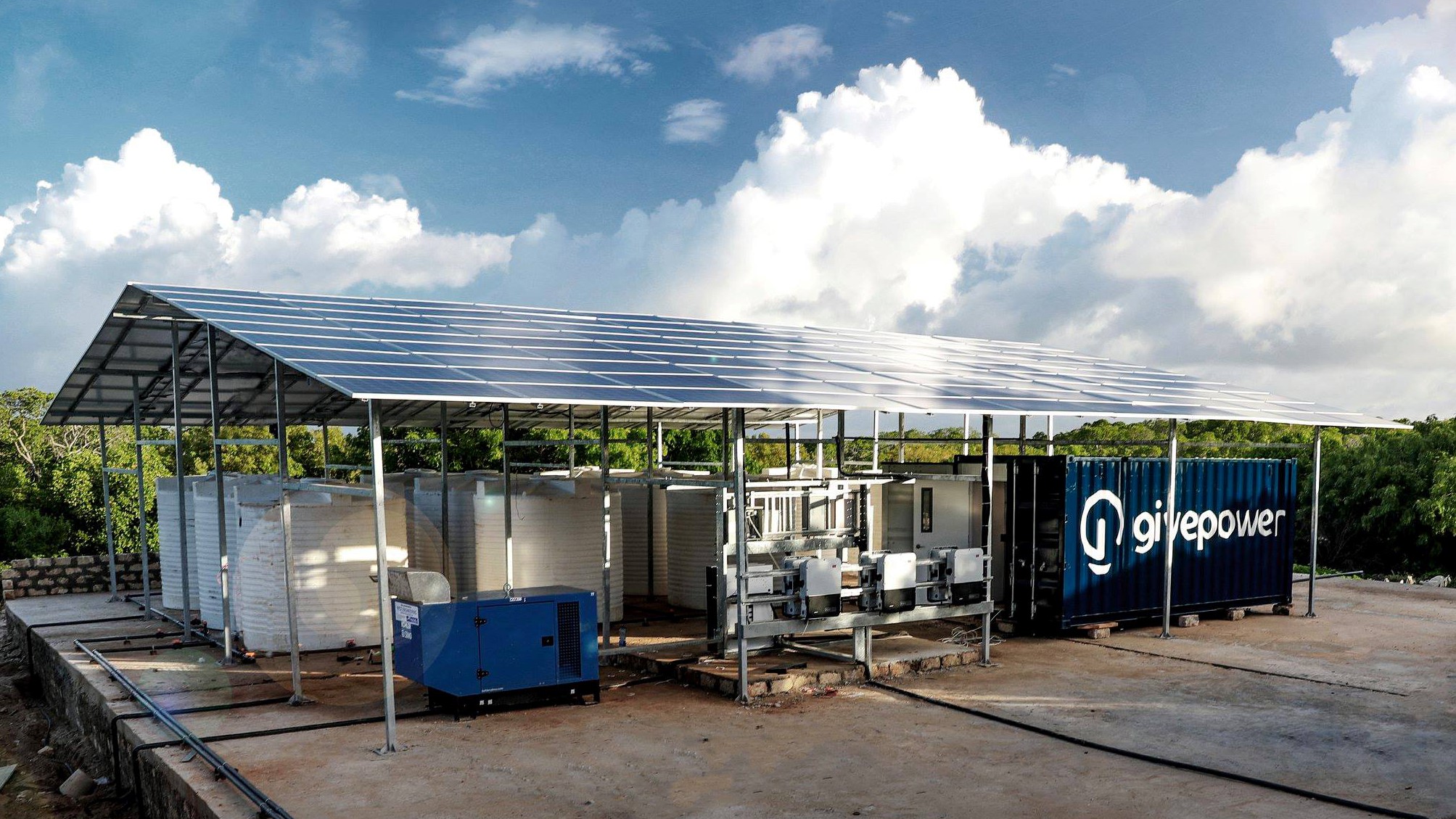GivePower's Solar Water Farm Max is shown, which has a solar panel roof above a desalination system and water tanks.