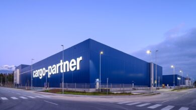 A blue warehouse with cargo-partner written on the side, against a blue sky