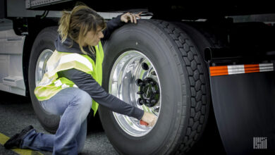 Truck driver inspecting tires.
