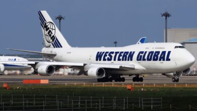 A white jumbo jet with Western Global Airlines in blue lettering on the ground at an airport.