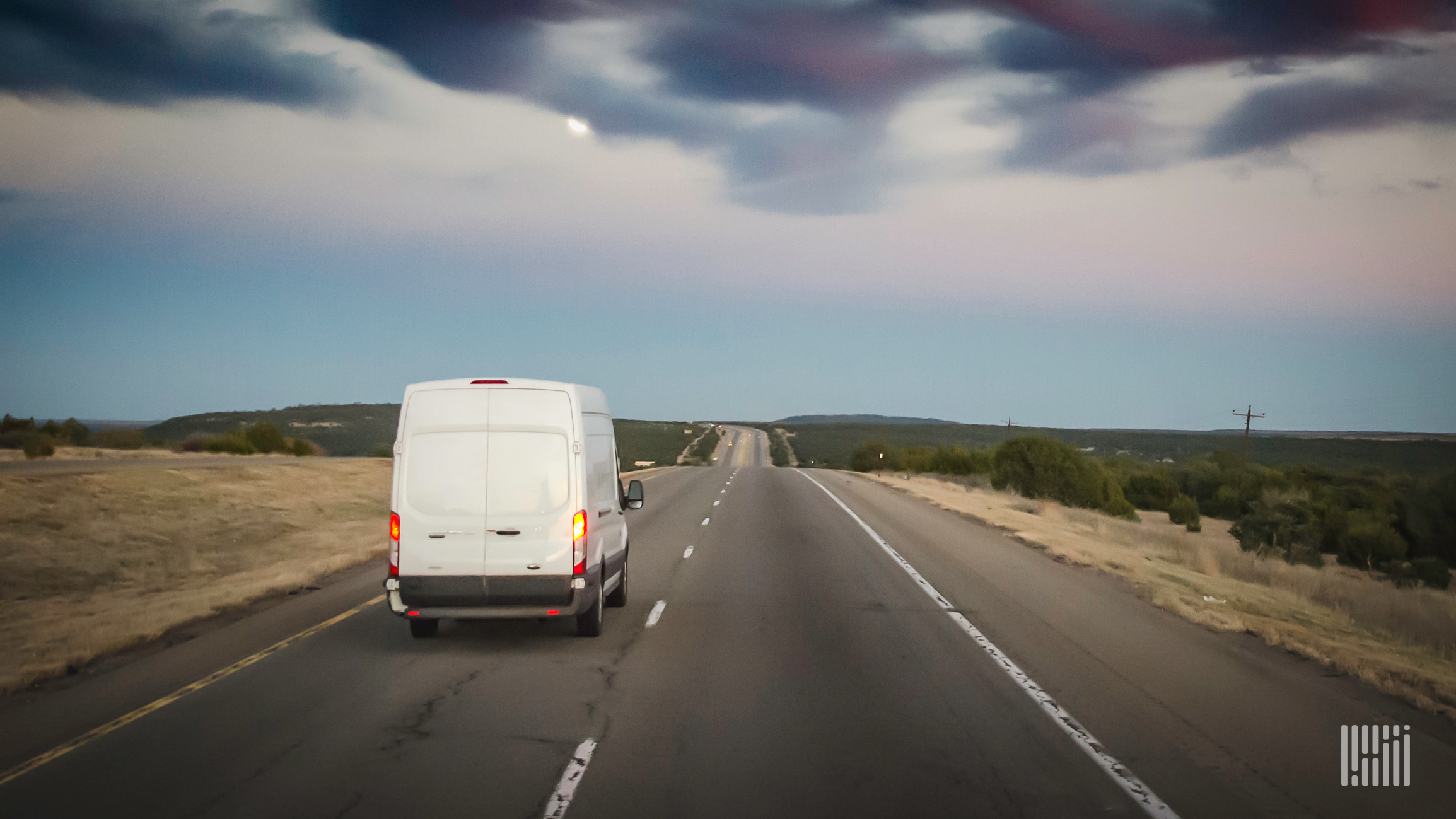 White van on highway at sunset