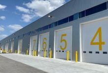 Dock doors at an airport painted with big yellow numbers, seen at an angle.